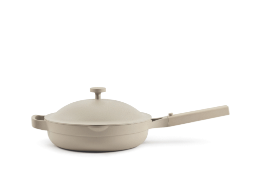 A beige, nonstick skillet with a matching domed lid and a long handle, shown against a plain white background.