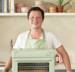 Kenji Lopez wearing green apron with green wonder oven pro