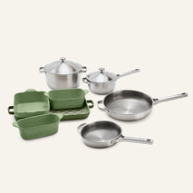 Titanium Pro Cookware + Bakeware Set 2.0 featuring stainless steel pots and pans alongside green ceramic loaf pans and a rectangular dish.