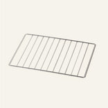 A rectangular metal wire cooling rack with parallel bars, viewed from an angle on a plain, light-colored background.