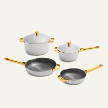 Titanium Pro Cookware Set 2.0 featuring two light-colored non-toxic pots with matching lids and two frying pans, all with gold-toned handles.