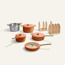 Set of orange cookware including pots and pans on a white background
