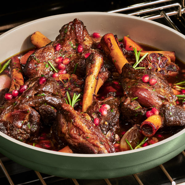 A braise with carrots and pomegranate seeds in a sage Dual Handle Always Pan in the oven.