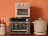 Multifunctional kitchen appliance with a blender and slow cooker on an orange background
